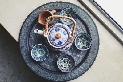 Directly above shot of teapot and cups arranged on tray