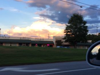 Cars on road against cloudy sky