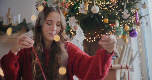 Young woman holding christmas tree