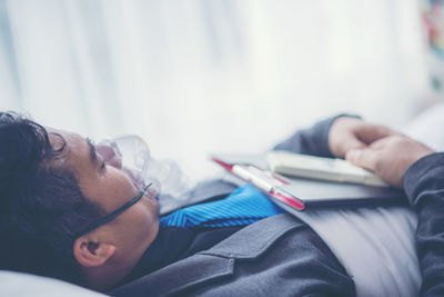 Businessman with oxygen mask lying at hospital