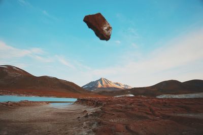 Stone over field at atacama desert against sky