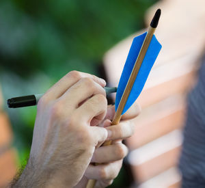 Close-up of hand writing on arrow