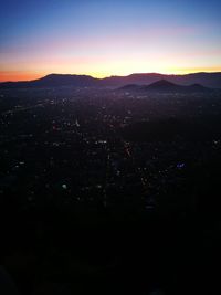 High angle view of illuminated city against sky at sunset