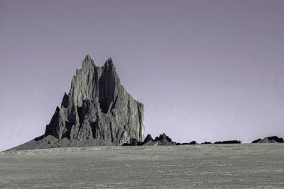 View of rock formation in sea against clear sky