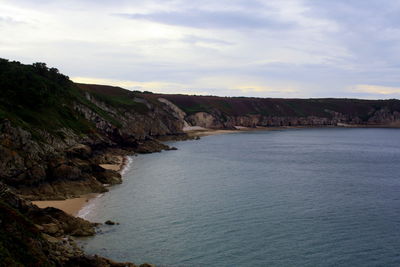 Scenic view of sea and mountains against sky