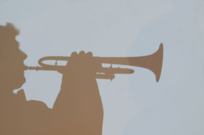 Low angle view of silhouette man holding umbrella against sky