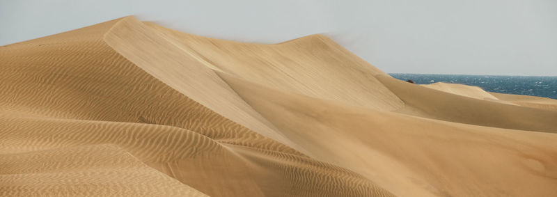 Close-up of sand at beach against sky