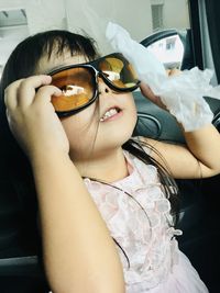 Portrait of cute girl holding sunglasses
