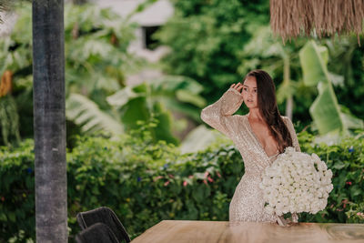 Young girl in a golden dress with a bouquet of white roses