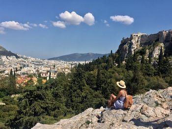 Woman standing on rock against mountain