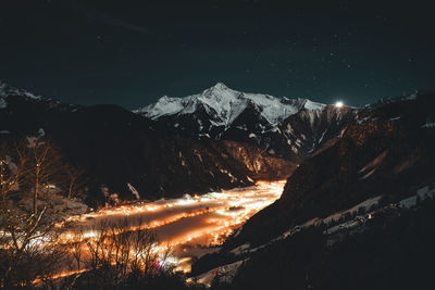 Scenic view of snowcapped mountains against sky at night