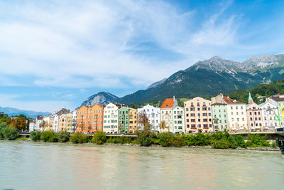 Buildings by mountains against sky