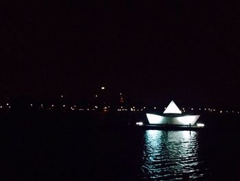 Illuminated bridge over river at night