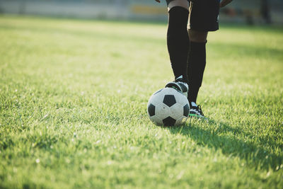 Low section of person with ball on field