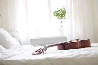 Acoustic guitar in bed at home