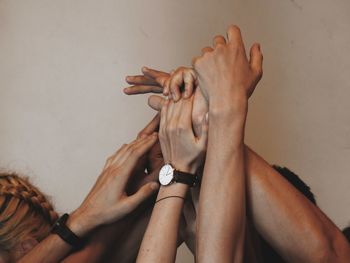 Midsection of man holding hands against wall