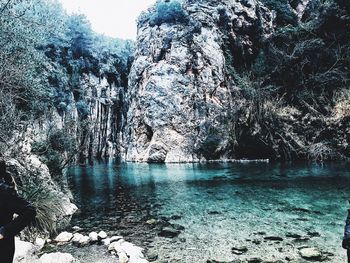 Scenic view of rock formation in water against sky