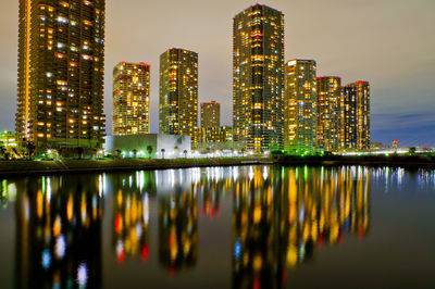 Reflection of illuminated buildings in city at night