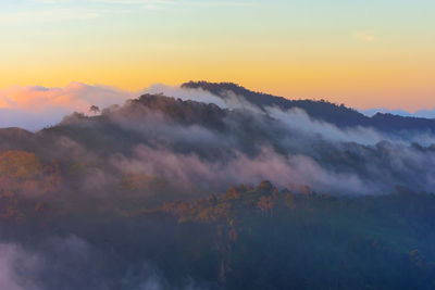 Scenic view of mountain against dramatic sky during sunset