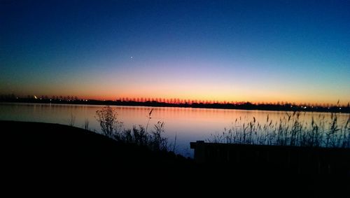 Scenic view of calm lake at sunset