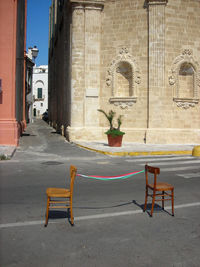 Empty chairs and table against buildings in city