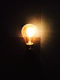 Close-up of illuminated light bulb in darkroom