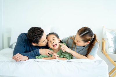 Friends and daughter on bed