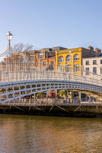 Bridge over river against sky in city