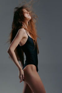 Young woman standing against wall