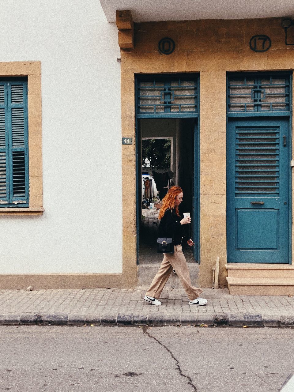 architecture, building exterior, built structure, full length, one person, window, day, wall, adult, lifestyles, home, building, door, women, entrance, casual clothing, leisure activity, house, city, facade, outdoors, wood, young adult, side view, residential district, footpath, person, blue