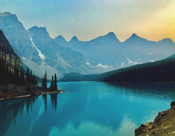 Scenic view of lake by mountains against sky