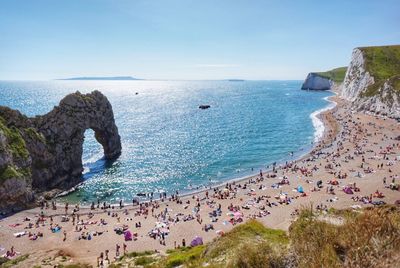 High angle view of people at durdle door beach against clear blue sky