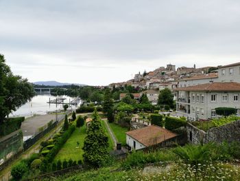 High angle view of townscape by river against sky