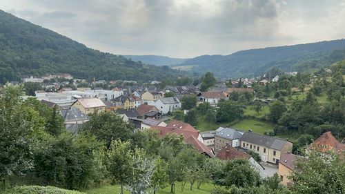 Panoramic view of townscape by mountains against sky