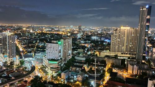 High angle view of illuminated cityscape against sky at night