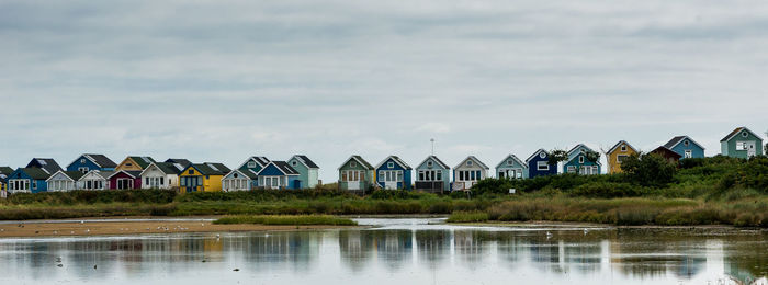 Colorful huts at beach against sky