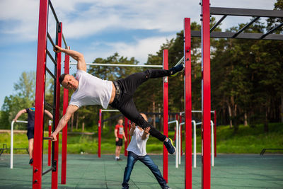 Side view of man climbing on playground
