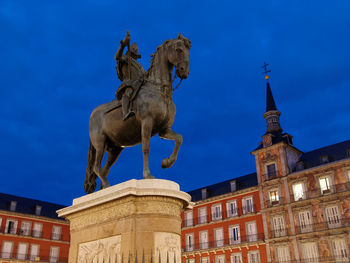 Low angle view of statue against blue sky