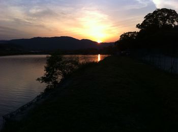 Scenic view of river against sky during sunset