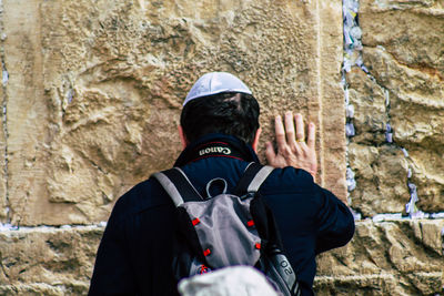 Rear view of man standing against wall