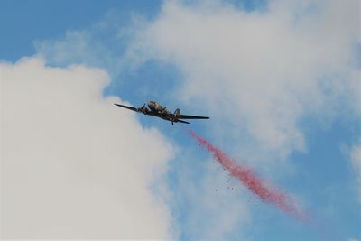 Low angle view of airplane flying against sky