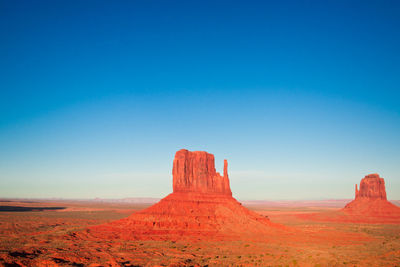 Scenic view of desert against clear blue sky