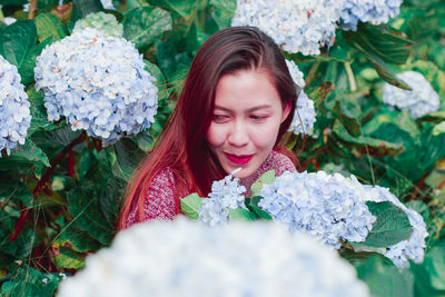 Mid adult woman by flowering plants in park