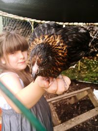 Portrait of girl holding hen