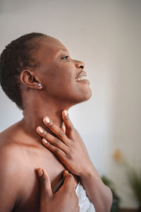 Side view of young man looking away against wall