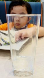 Reflection of woman drinking glass on table