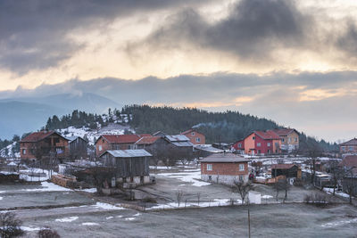 Houses in city against sky during winter