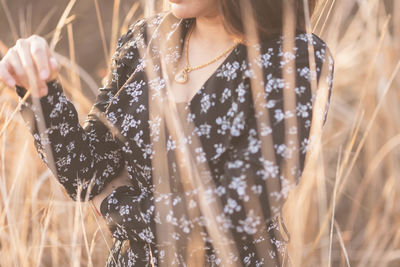 Midsection of woman standing amidst grass