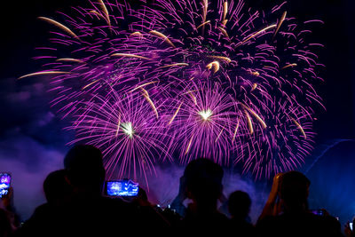 People watching firework display at night