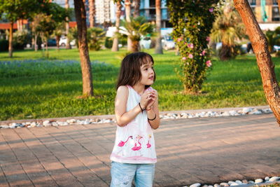 Full length of girl standing against trees